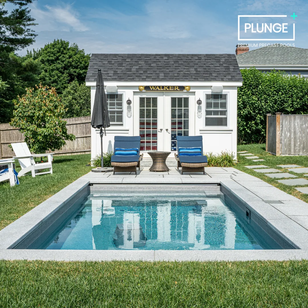 Backyard with swimming pool, two lounge chairs, small table, shed with sign that says 'Walker', and garden surroundings.