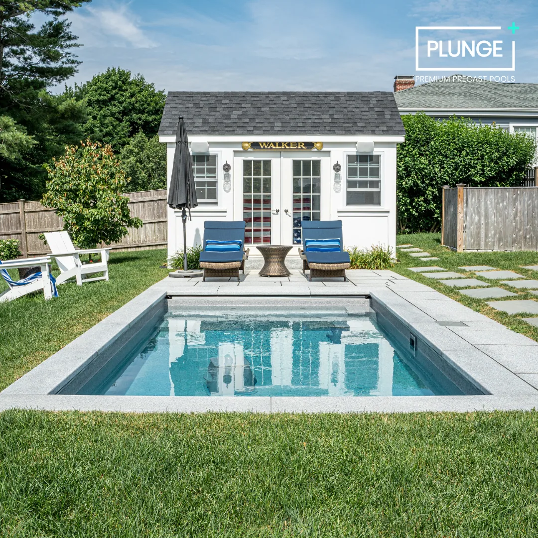 Backyard with a small pool, two lounge chairs with blue cushions, a small round table, a white shed with 'Walker' sign, umbrella, Adirondack chair, stepping stones, and fenced yard with green trees.